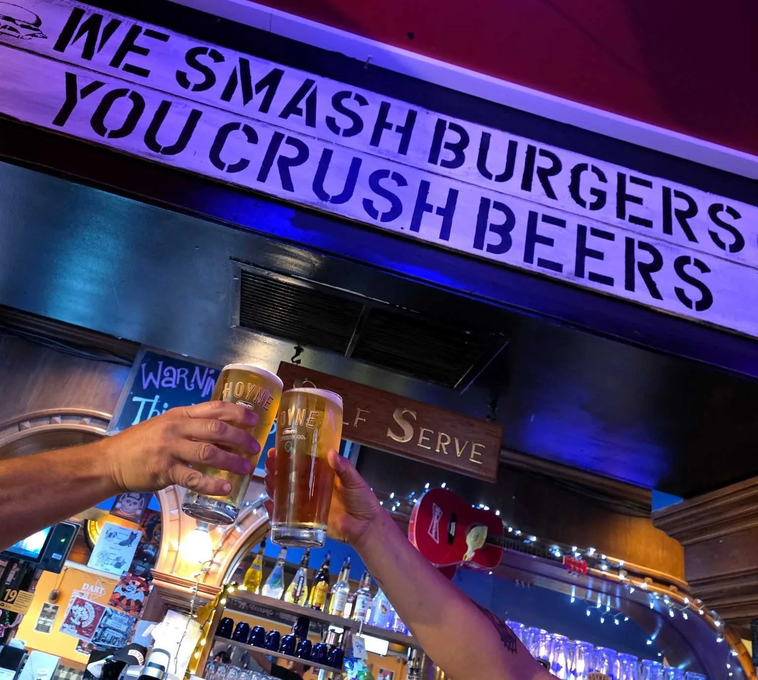 We Smash Burgers You Crush Beers sign at The Phoenix